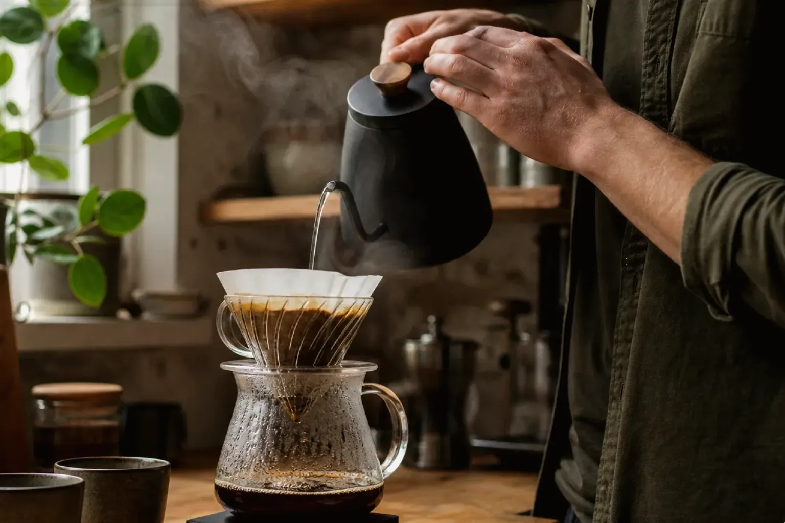 Filterkaffee wird mit einem Schwanenhalskessel von Hand in einer Küche aufgegossen – gezeigt für Lavazza im Markenprofil.