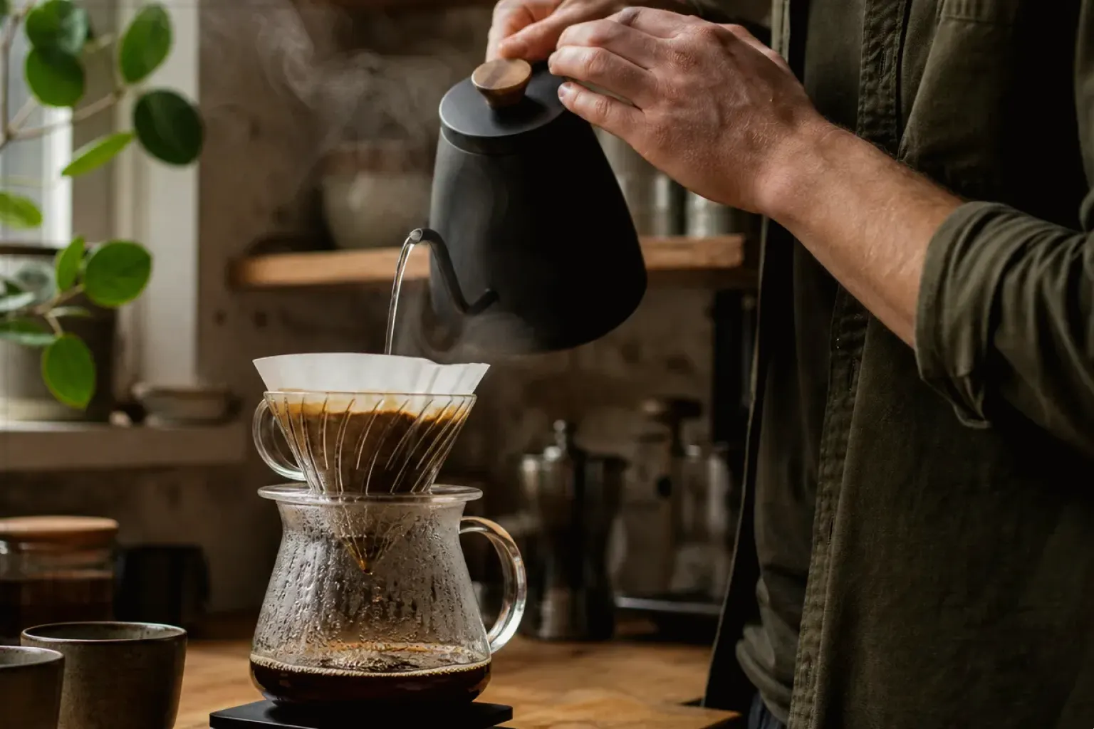 Filterkaffee wird mit einem Schwanenhalskessel von Hand in einer Küche aufgegossen – gezeigt für Fehlerhilfe im Ratgeberbereich.