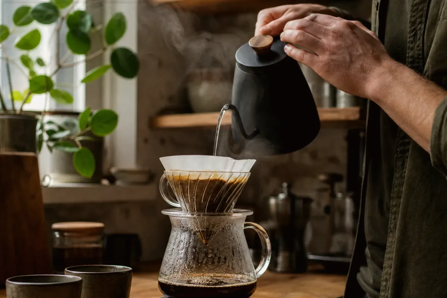 Filterkaffee wird mit einem Schwanenhalskessel von Hand in einer Küche aufgegossen – gezeigt für Fehlerhilfe im Ratgeberbereich.