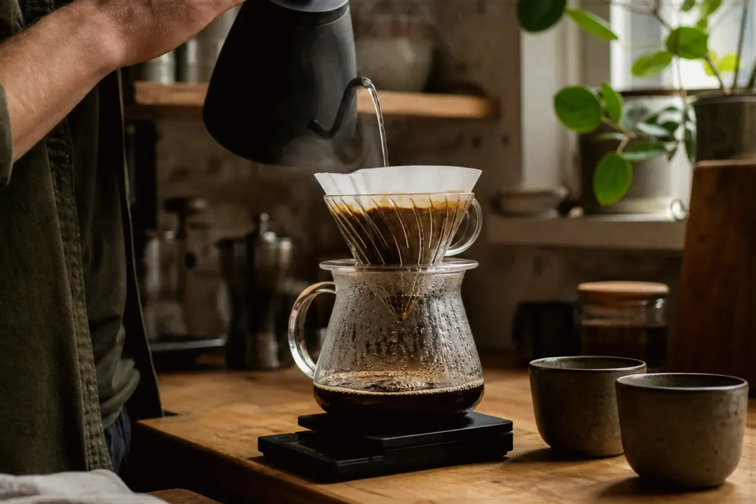Filterkaffee wird mit einem Schwanenhalskessel von Hand in einer Küche aufgegossen – gezeigt für Zubereitung im Ratgeberbereich.